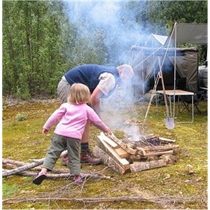 A toddler helping with collecting wood