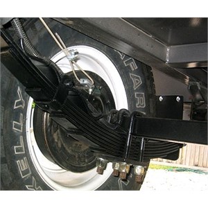 Undercarriage of a camper trailer showing the brakes and leaf springs