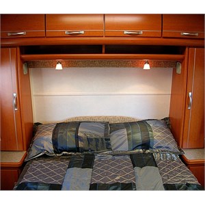 Bedroom showing an overhead shelf and storage lockers