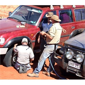 Tour operator changing a flat tyre