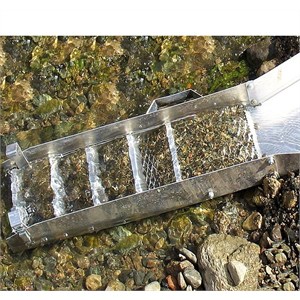 Sluice box sifting earth and rocks in a stream