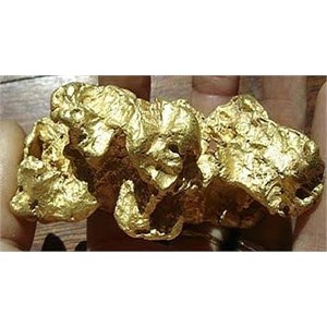 Holding a large gold nugget in the palm of the hand