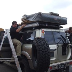Mounting the roof top taj.  The tongue out certainly helps. Note the custom HF areal mount in extended position.