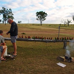 the hunters preparing the redclaw, watched by parrots