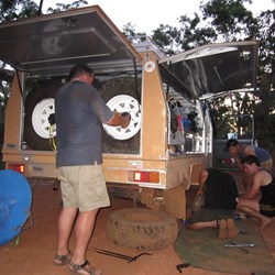 The work crew getting ready to seat the studs and new wheel.