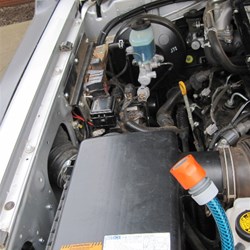 Air filter box back in.  Hoses for pick up (bottom hose) and water delivery (top hose)