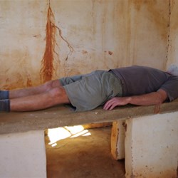 John tries out the mortuary slab at Hermannsburg Historic precinct (or is he 'planking')