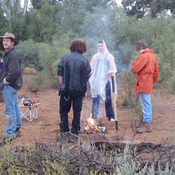Gathered around the fire as the rain starts