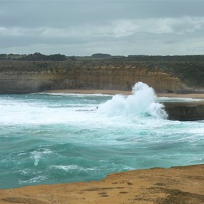 A wave breaks over Thunder Rock