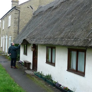Cottages with thatched roofs, low eaves and doors.