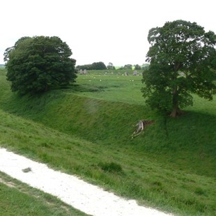 Avebury, showing the deep ditch and earthen walls with some of the stones in the distance