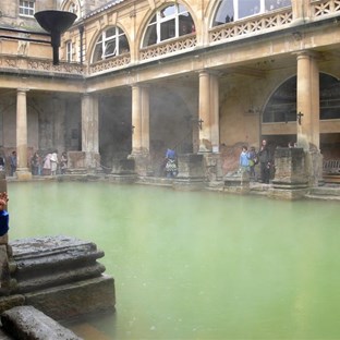 Mist hangs over the warm water in the Roman baths