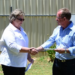 Geoff presents a cheque to Debbie Adams from the RFDS