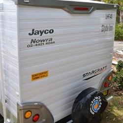 rear of van with signage and ExplorOz garbage bag on rear spare
