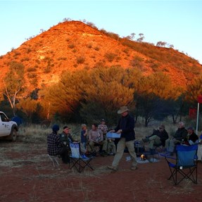 Gathering around the campfire as the sun sets