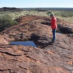 Fiona inspecting rock holes on top of the outcrop where the trig point is located 