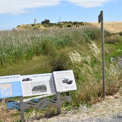 The history signs and the lighthouse in the background