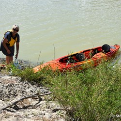 Securing the kayak on the side of the steep river bank