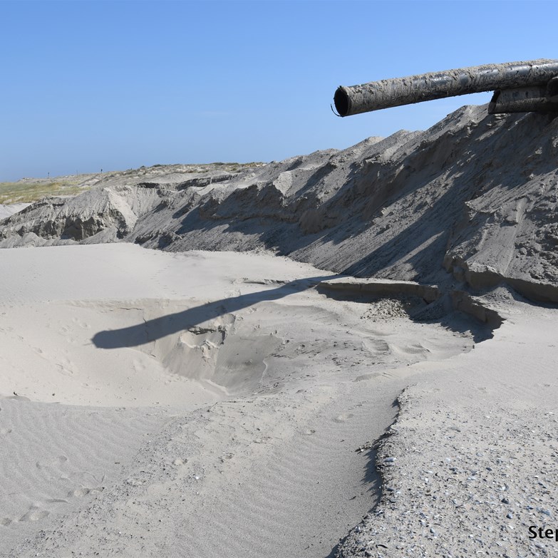 Large stockpiles of dredged sand on the beach