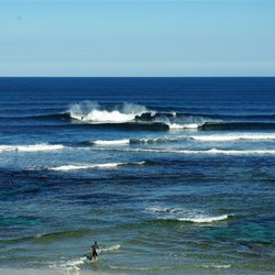 surfers catch a wave near Margaret River mouth