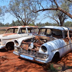 2 old cars left to rust on the red dirt...taken on a drive around the station