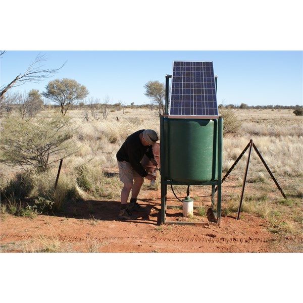 Outback Al lifting a drink from Cooper Hill Bore - 14 July 2009