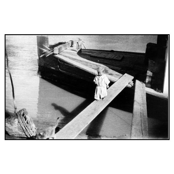 Jocelyn Creager, at 13 months, follows her cat along the gangplank