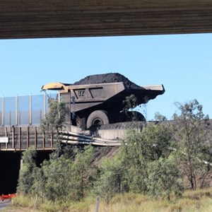 A loaded dump truck on the overpass.